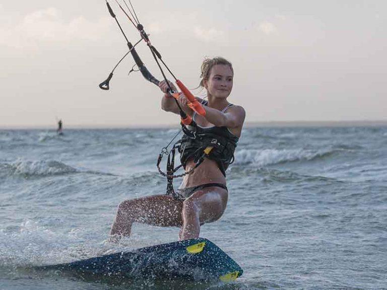 Kite girl riding on a Kiteboard in the water